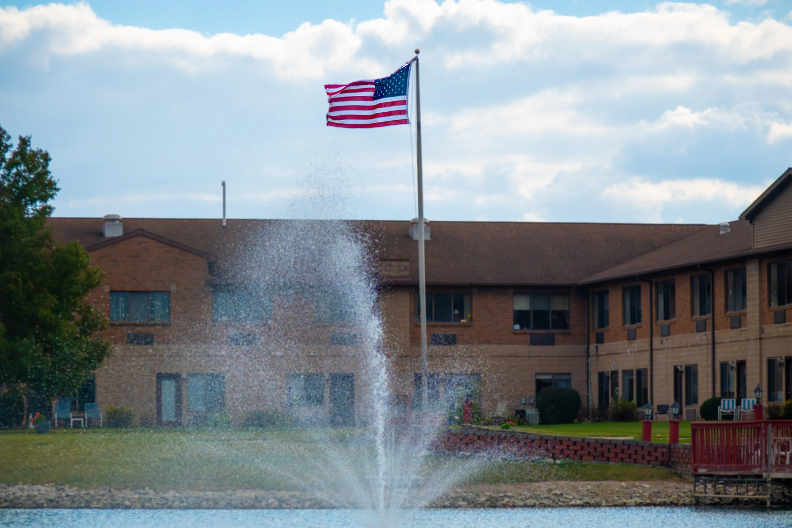 US flag over building & fountain
